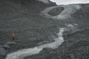 Ein Gletscher-Schmelzwasserfluss mit einer Forscherin